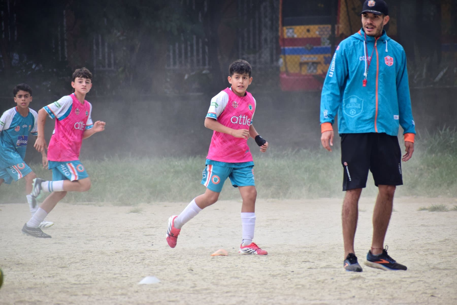Posada conduce el balón en el entrenamiento, con el entrenador al fondo
